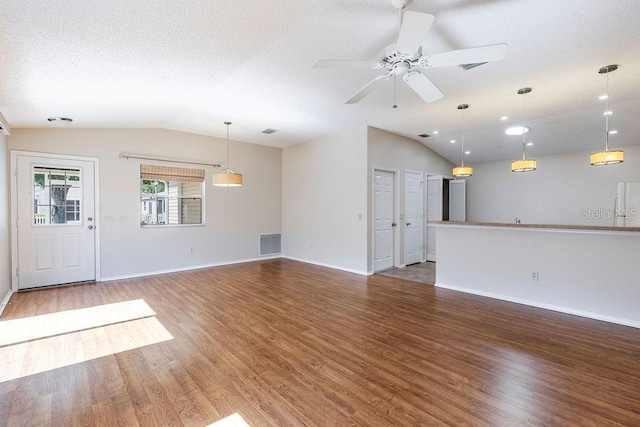 1667 Osprey Ave, The Villages, FL 32162 - unfurnished living room with lofted ceiling, a textured ceiling, visible vents, a ceiling fan, and wood finished floors