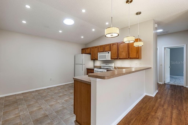 1667 Osprey Ave, The Villages, FL 32162 - kitchen featuring a textured ceiling, hanging light fixtures, brown cabinetry, white appliances, and recessed lighting