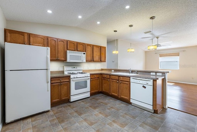 1667 Osprey Ave, The Villages, FL 32162 - kitchen featuring a peninsula, white appliances, a sink, vaulted ceiling, and brown cabinetry