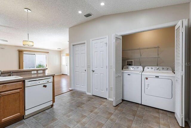 1667 Osprey Ave, The Villages, FL 32162 - clothes washing area with washing machine and clothes dryer, a sink, a textured ceiling, and visible vents