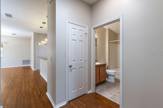 1667 Osprey Ave, The Villages, FL 32162 - hallway with baseboards, visible vents, wood finished floors, and a textured ceiling