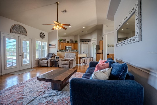 15141 Farm Rd, Groveland, FL 34736 - living area featuring light wood-type flooring, french doors, high vaulted ceiling, visible vents, and a ceiling fan