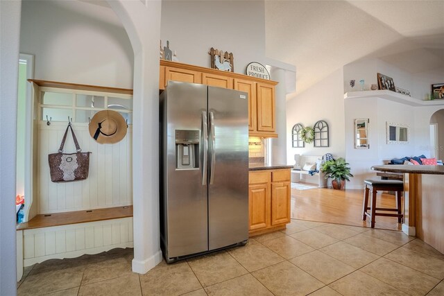 15141 Farm Rd, Groveland, FL 34736 - kitchen featuring open floor plan, arched walkways, stainless steel fridge, and light tile patterned floors