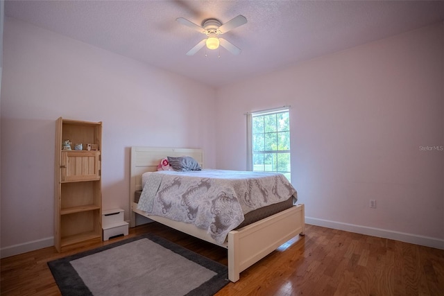 15141 Farm Rd, Groveland, FL 34736 - bedroom with baseboards, ceiling fan, and wood finished floors