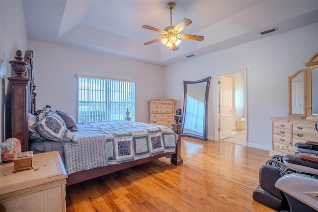 15141 Farm Rd, Groveland, FL 34736 - bedroom featuring visible vents, baseboards, ceiling fan, light wood-type flooring, and a tray ceiling