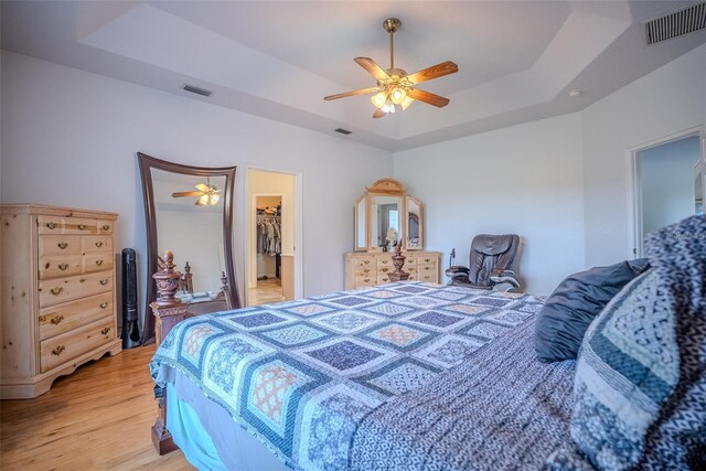 15141 Farm Rd, Groveland, FL 34736 - bedroom with light wood-type flooring, a raised ceiling, and visible vents