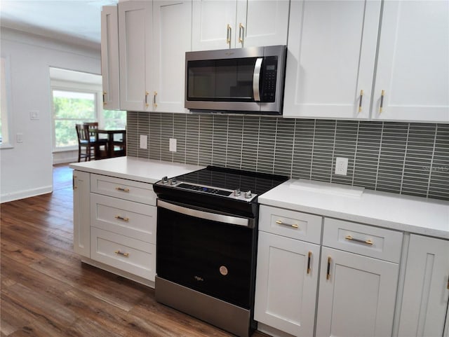 kitchen with stainless steel microwave, light countertops, dark wood-type flooring, range with electric stovetop, and decorative backsplash