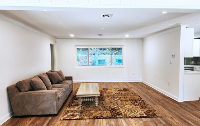 living area featuring recessed lighting, visible vents, baseboards, and wood finished floors
