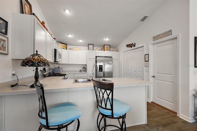 kitchen featuring a sink, light countertops, a peninsula, appliances with stainless steel finishes, and visible vents