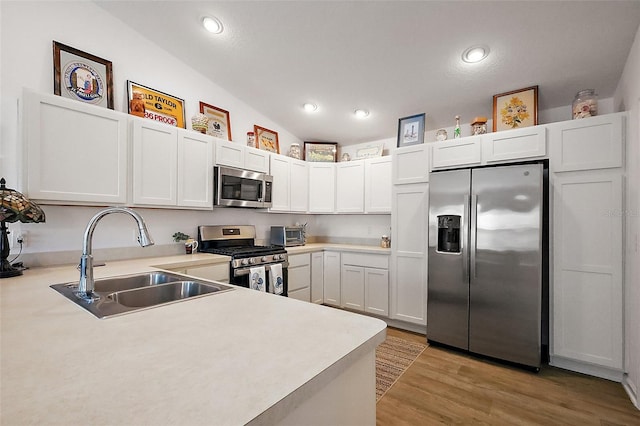 kitchen featuring a sink, light wood-type flooring, recessed lighting, light countertops, and appliances with stainless steel finishes