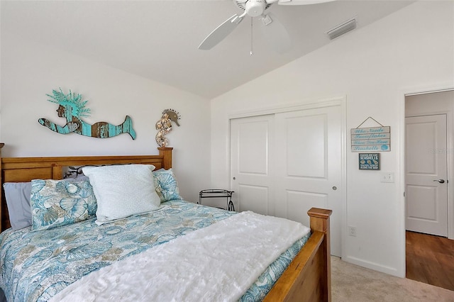 carpeted bedroom featuring vaulted ceiling, visible vents, a closet, and ceiling fan