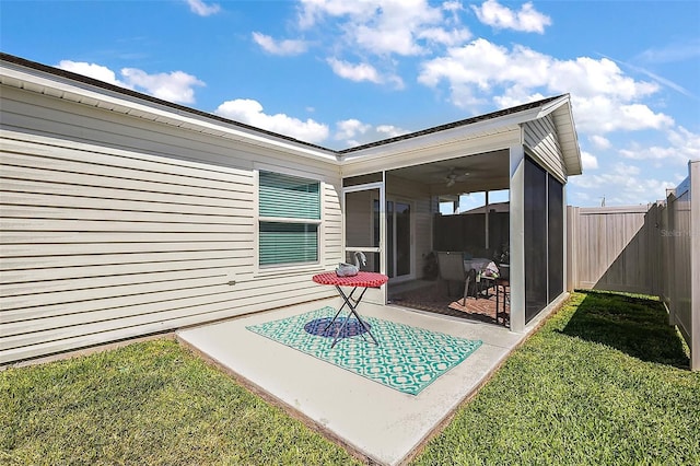 exterior space featuring a fenced backyard, a sunroom, and a yard
