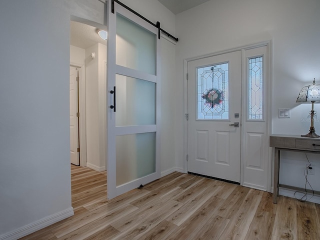 1010 Ventura Dr, The Villages, FL 32159 - foyer entrance with light wood-type flooring, baseboards, and a barn door
