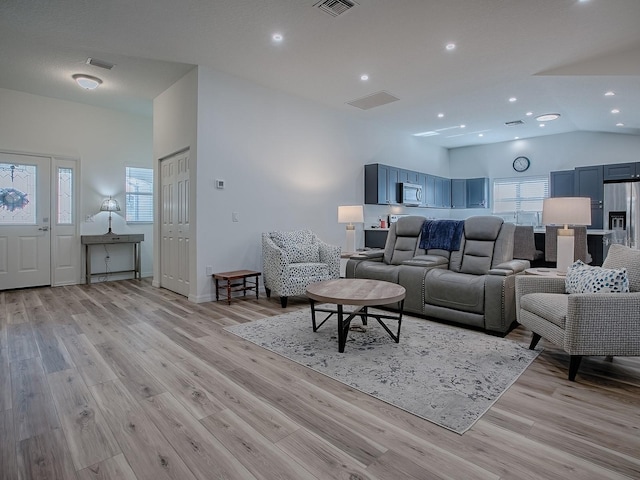 1010 Ventura Dr, The Villages, FL 32159 - living area with light wood-style floors, lofted ceiling, and a wealth of natural light