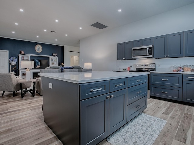 1010 Ventura Dr, The Villages, FL 32159 - kitchen with visible vents, light countertops, light wood-style floors, stainless steel appliances, and a kitchen island