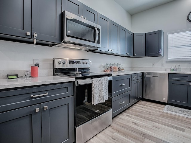 1010 Ventura Dr, The Villages, FL 32159 - kitchen with appliances with stainless steel finishes, light wood finished floors, and light stone counters