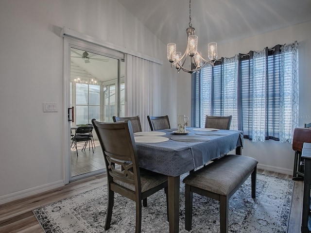 1010 Ventura Dr, The Villages, FL 32159 - dining area featuring a chandelier, baseboards, vaulted ceiling, and light wood-style flooring