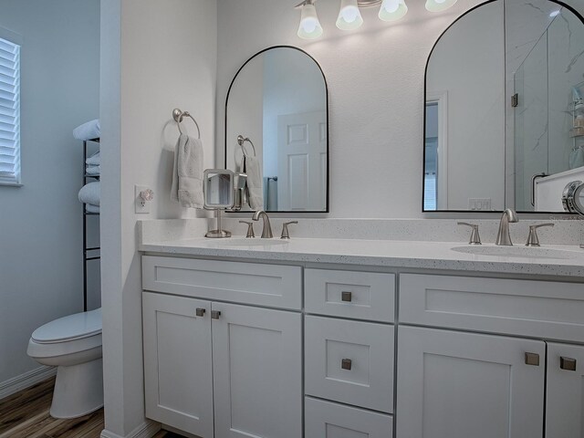 1010 Ventura Dr, The Villages, FL 32159 - full bath featuring double vanity, a sink, toilet, and wood finished floors