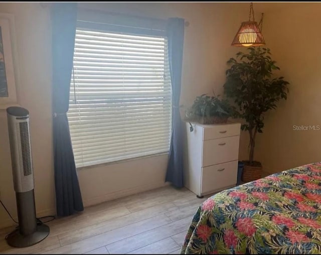 bedroom featuring light wood-style floors and baseboards