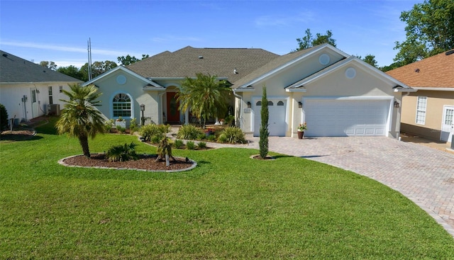 single story home featuring a garage, stucco siding, a front yard, and decorative driveway