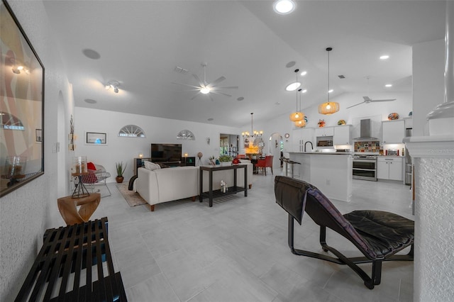 living area featuring visible vents, recessed lighting, vaulted ceiling, and ceiling fan with notable chandelier