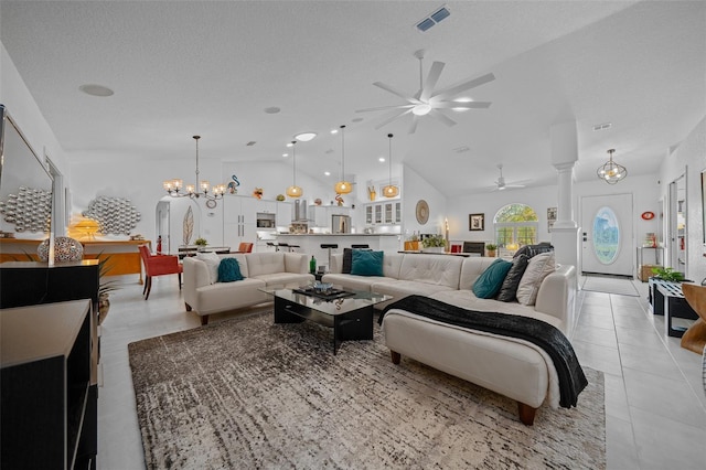living room with ceiling fan with notable chandelier, light tile patterned floors, ornate columns, visible vents, and lofted ceiling