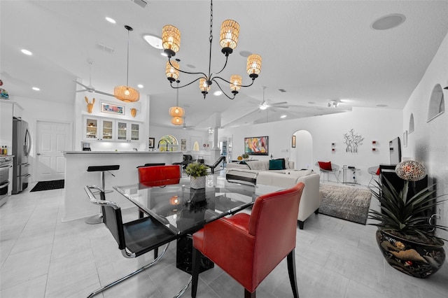 dining space featuring vaulted ceiling, recessed lighting, light tile patterned flooring, arched walkways, and ceiling fan with notable chandelier