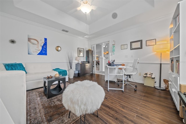 interior space featuring visible vents, a ceiling fan, crown molding, a tray ceiling, and wood finished floors