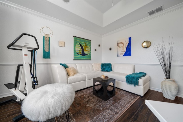 living room featuring ornamental molding, visible vents, wood finished floors, a raised ceiling, and baseboards