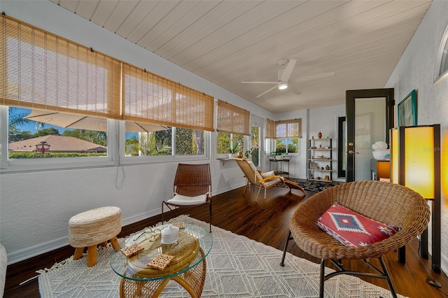 sunroom featuring baseboards and wood finished floors