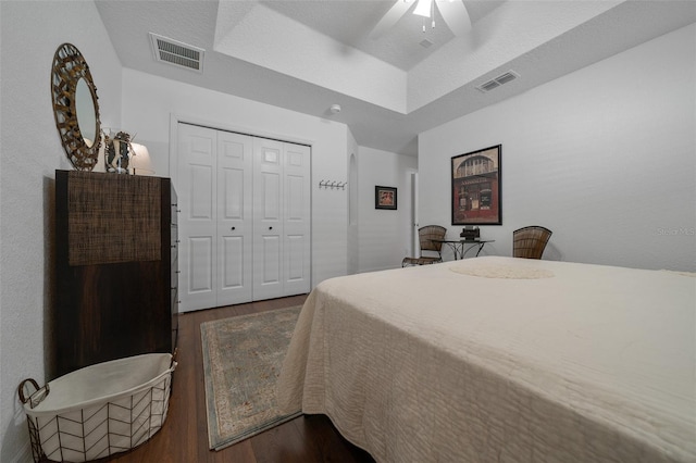 bedroom featuring dark wood-type flooring, visible vents, and a closet
