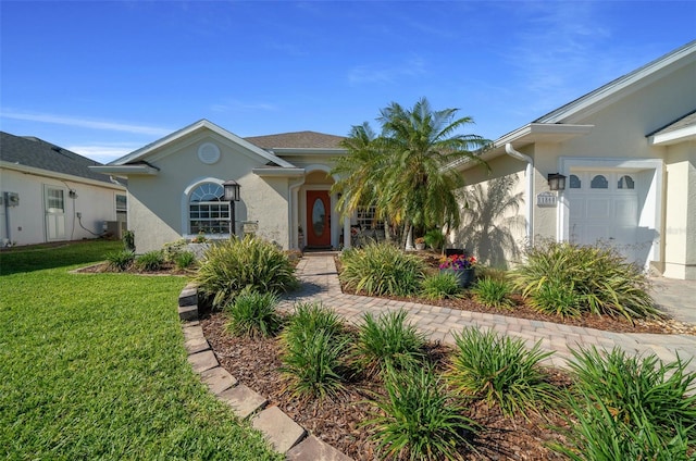 single story home featuring a front lawn, central air condition unit, a garage, and stucco siding
