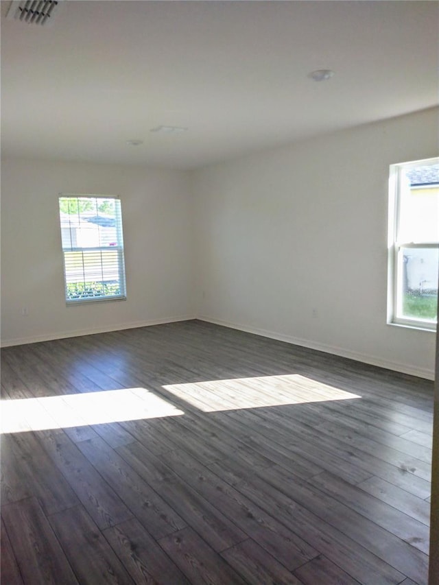 27 Perch Dr, Kissimmee, FL 34759 - empty room featuring plenty of natural light, dark wood finished floors, and baseboards