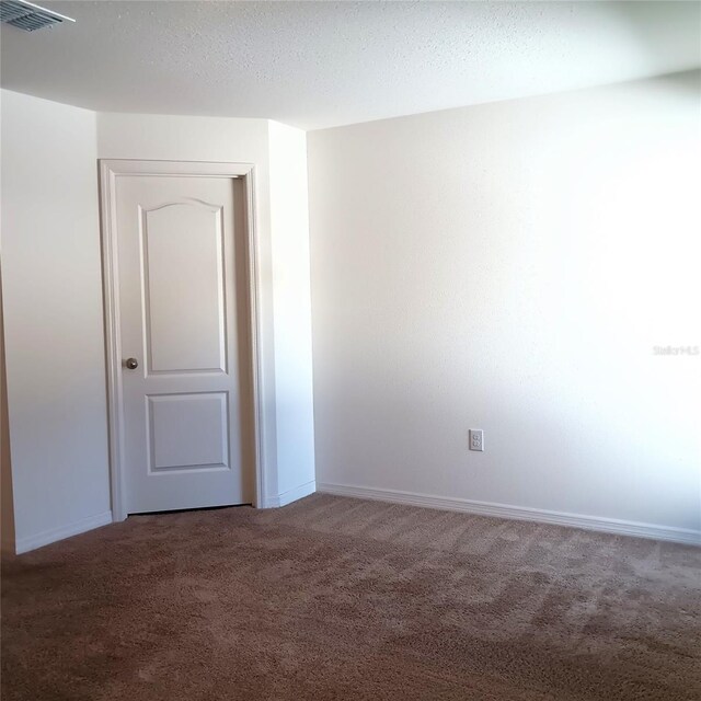 27 Perch Dr, Kissimmee, FL 34759 - empty room with carpet floors, baseboards, and a textured ceiling