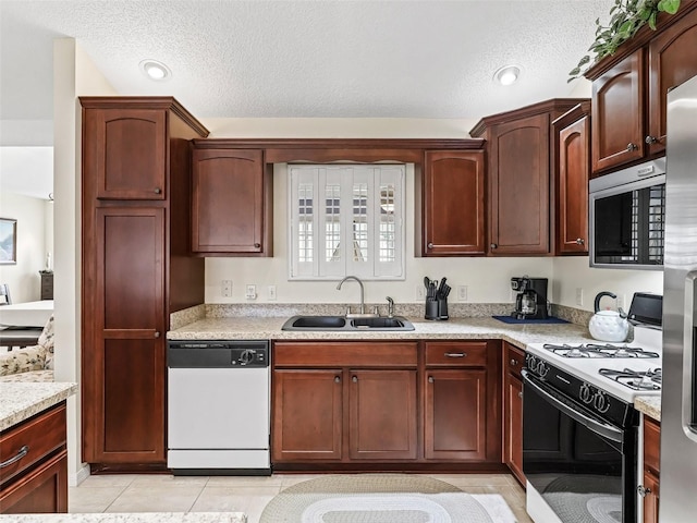 1307 Galindo Pl, The Villages, FL 32159 - kitchen featuring gas range, stainless steel microwave, light countertops, a sink, and white dishwasher