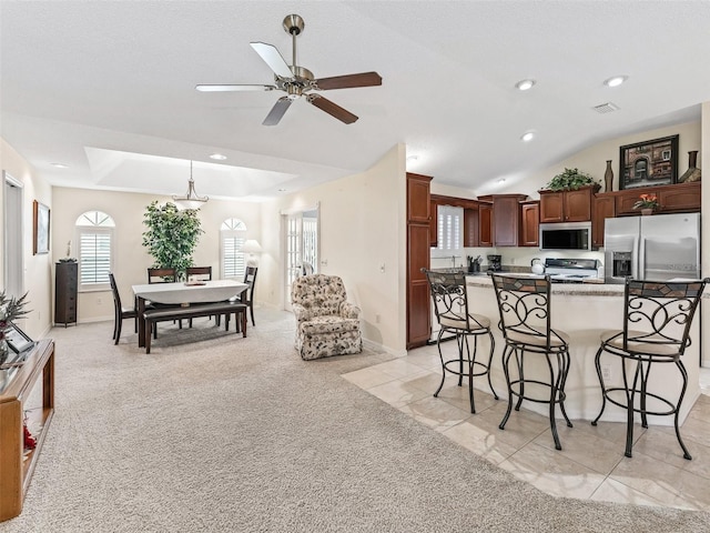 1307 Galindo Pl, The Villages, FL 32159 - kitchen featuring a breakfast bar, light carpet, visible vents, ceiling fan, and stainless steel appliances