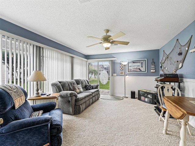 1307 Galindo Pl, The Villages, FL 32159 - carpeted living area with wainscoting, a textured ceiling, and a ceiling fan