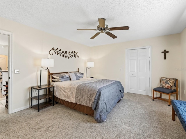 1307 Galindo Pl, The Villages, FL 32159 - carpeted bedroom with a textured ceiling, a closet, baseboards, and a ceiling fan