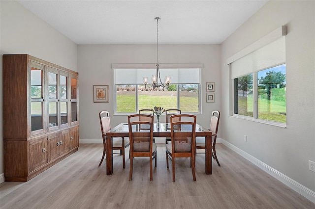 dining space with a notable chandelier, light wood-type flooring, and baseboards