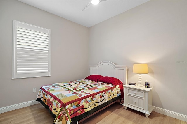bedroom with light wood-type flooring, baseboards, and a ceiling fan