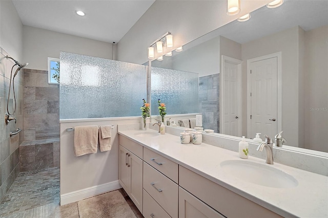 bathroom featuring tile patterned floors, double vanity, a sink, and walk in shower