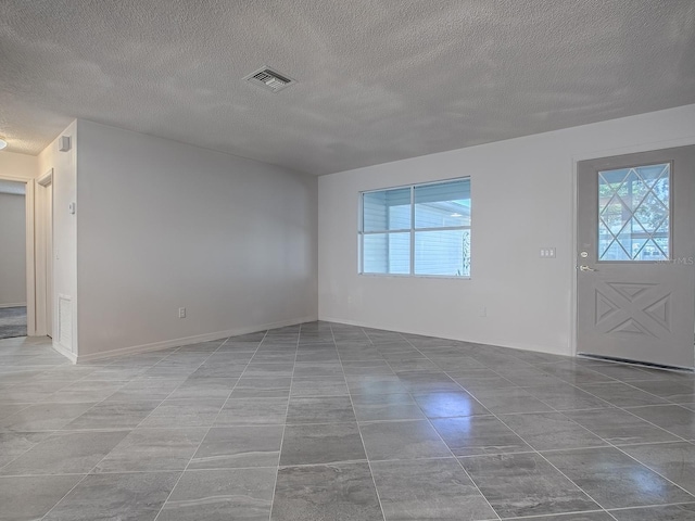 entryway featuring a textured ceiling, visible vents, and baseboards