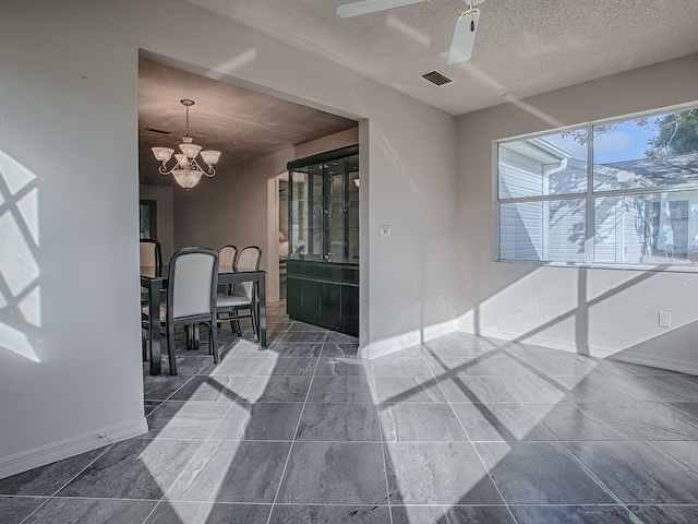unfurnished room featuring visible vents, baseboards, and a notable chandelier