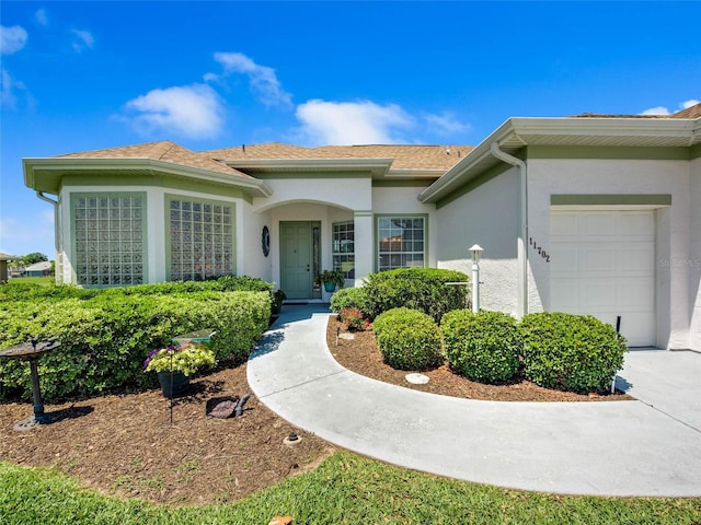 entrance to property featuring a garage and stucco siding