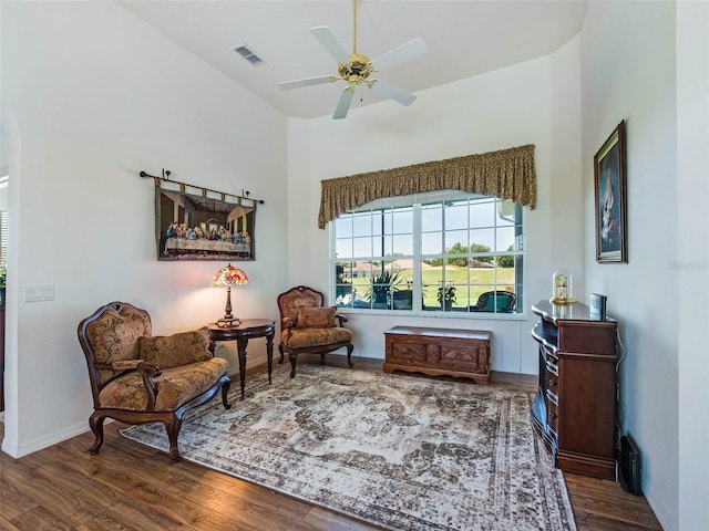 living area with wood finished floors, baseboards, a ceiling fan, and visible vents