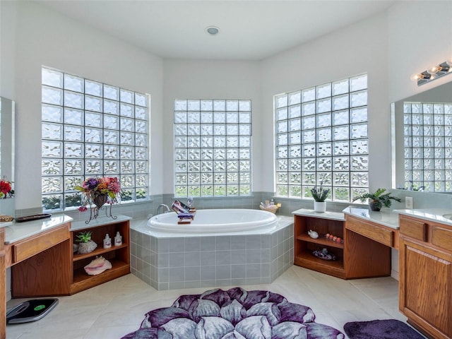 bathroom with tile patterned flooring, vanity, a garden tub, and a healthy amount of sunlight