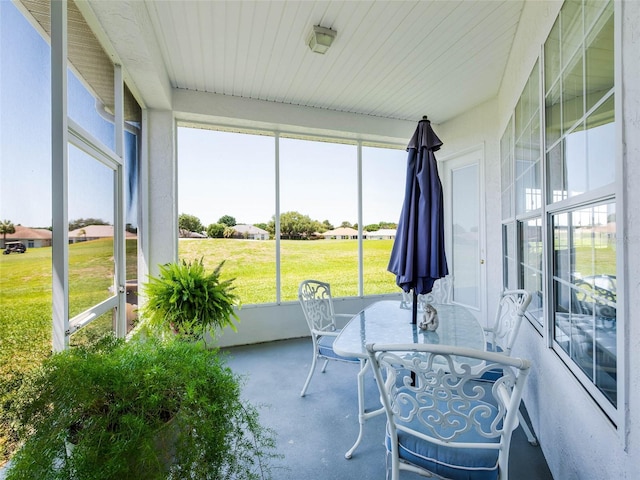 sunroom / solarium featuring concrete flooring and outdoor dining space