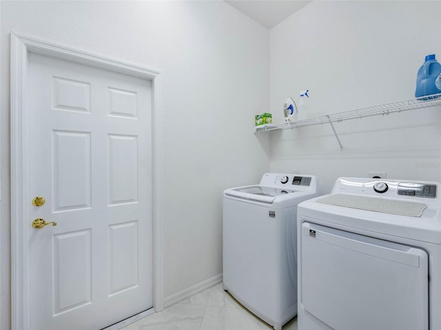 laundry room featuring laundry area, marble finish floor, baseboards, and washer and clothes dryer