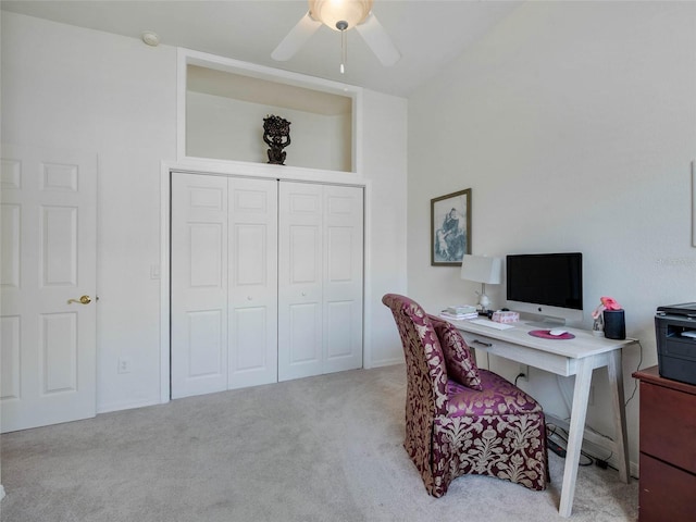 carpeted home office featuring a ceiling fan
