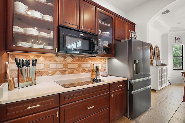 kitchen with crown molding, light tile patterned floors, visible vents, black appliances, and light countertops
